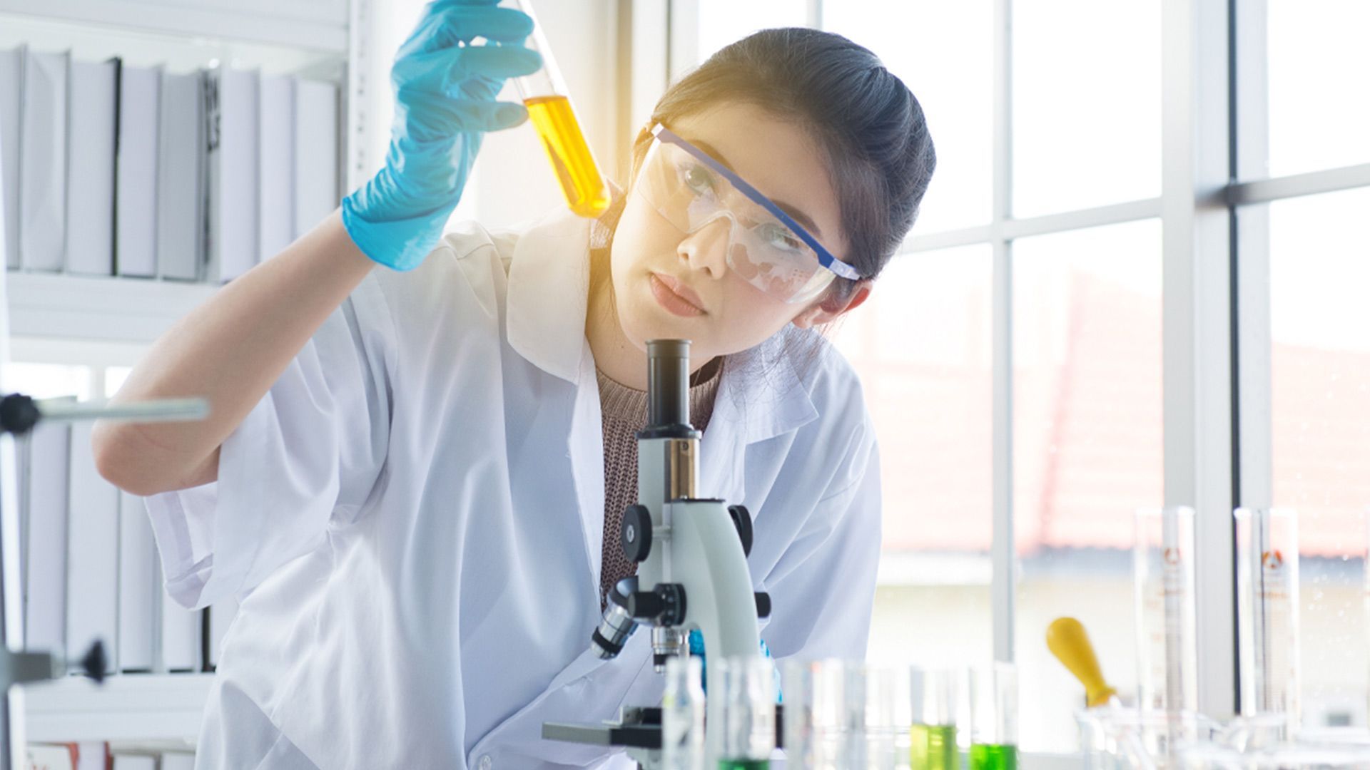 A scientist looking at a test tube